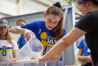 a girl pouring water into the mixture